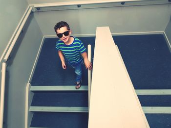 Portrait of boy wearing sunglasses on staircase