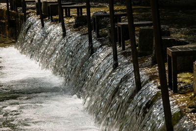 Water splashing on wooden post in sea