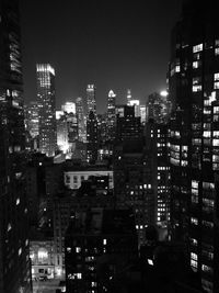 Illuminated cityscape against clear sky at night