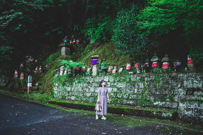 Woman standing by plants in park