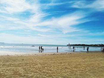 People on beach against sky