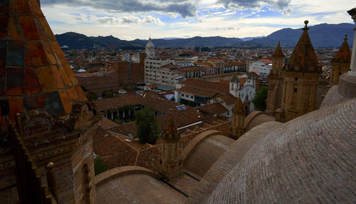 Aerial view of city against cloudy sky