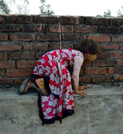 Rear view of woman against wall