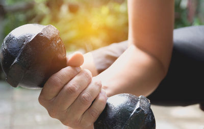 Cropped hand of man lifting dumbbell