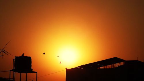 Low angle view of silhouette buildings against sky during sunset