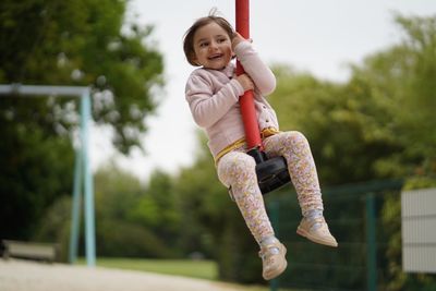 Happy girl sitting on ride at playground