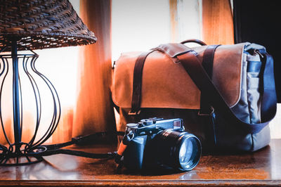 Close-up of camera and bag on table