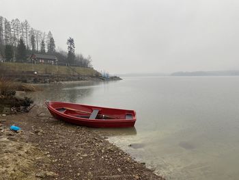 Boat moored on beach against sky