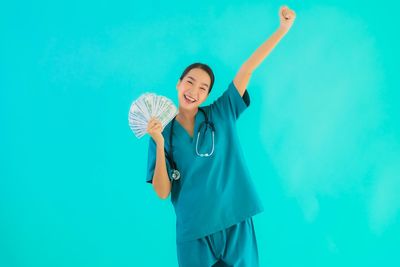 Full length of woman standing against blue background