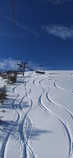 Ski lift on snowcapped mountain against sky