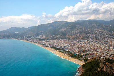 High angle view of townscape by sea against sky