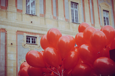 Low angle view of red balloons on building