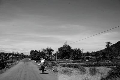 Road amidst trees against sky