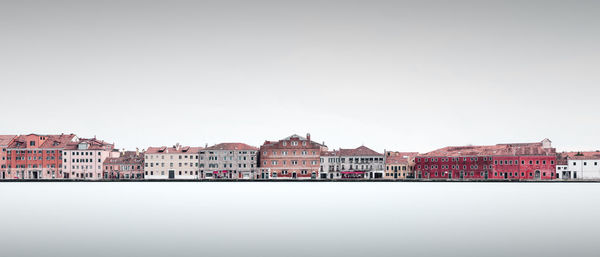 River by townscape against clear sky