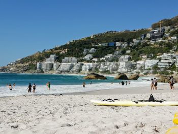 People on beach against clear sky