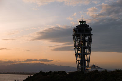 Silhouette water tower against sky during sunset