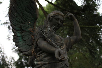 Low angle view of statue against trees