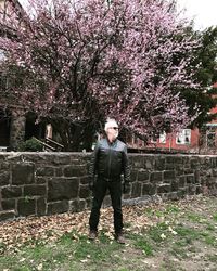 Full length portrait of man standing against tree