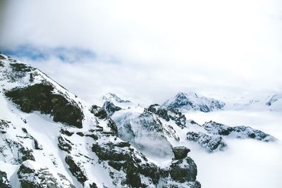 Low angle view of snowcapped mountains against sky