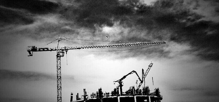 sky, crane - construction machinery, low angle view, cloud - sky, cloudy, construction site, development, crane, fuel and power generation, industry, construction, weather, overcast, cloud, construction industry, alternative energy, wind turbine, environmental conservation, wind power, silhouette