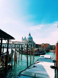 Boats moored of grand canal by santa maria della salute against sky