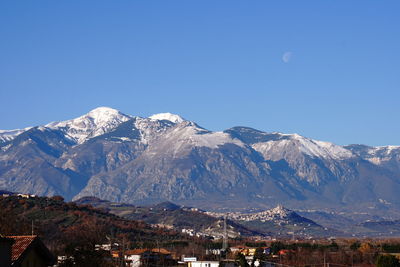 Scenic view of snowcapped mountains against clear blue sky