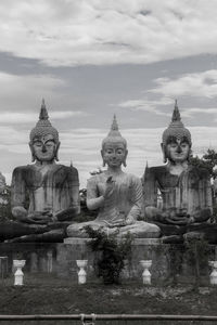 Weathered buddha statues against sky