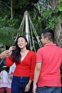 Happy young couple standing on mobile phone