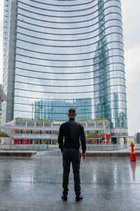 Full length rear view of man standing in city