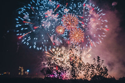 Low angle view of firework display at night