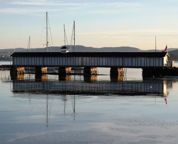 Pier on sea against sky during sunset