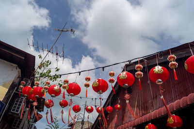 Low angle view of lanterns hanging against sky