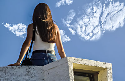 Rear view of woman standing against sky