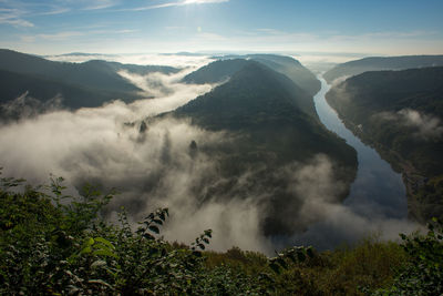 Scenic view of mountains and river in the clouds against sky