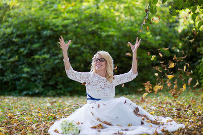 Portrait of young woman playing with leaves