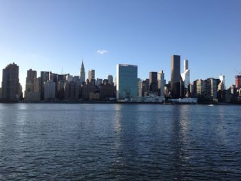 Sea and cityscape against clear blue sky