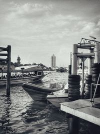 Built structure by river against cloudy sky