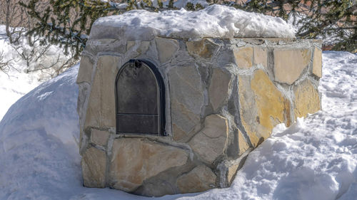 Snow covered rock by building