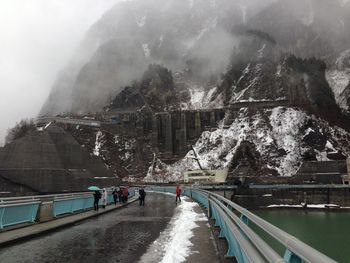 People on snow covered road during rainy season