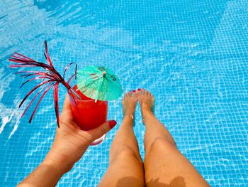 Low section of bare feet in swimming pool