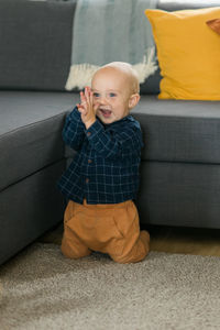 Portrait of boy sitting on sofa at home