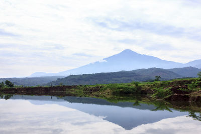 Scenic view of lake and mountains against sky