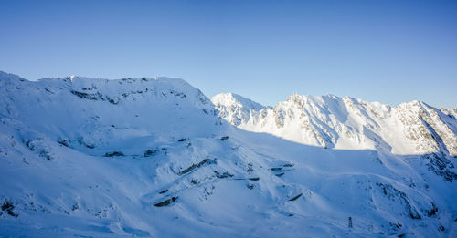 Scenic view of snowcapped mountains against clear blue sky