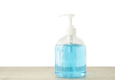 Close-up of glass bottle on table against white background