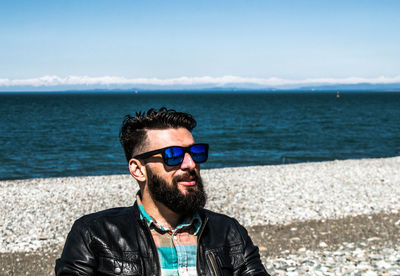 Portrait of man wearing sunglasses against sea