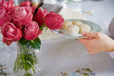 Close-up of hand holding bouquet of red roses