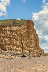 Full length of man sitting on rock