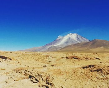 Scenic view of desert against clear blue sky