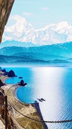 Scenic view of sea and mountains against sky