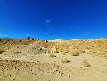 Scenic view of desert against blue sky